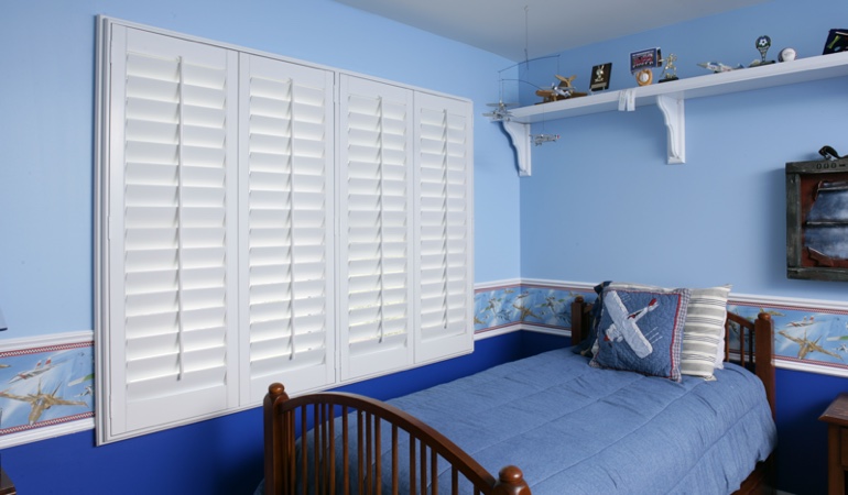White plantation shutters in blue kids bedroom in Cleveland 